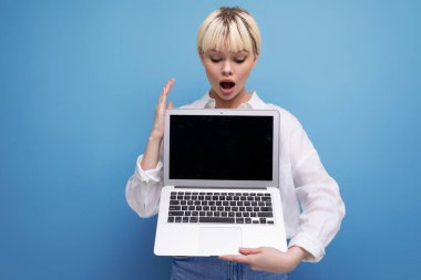 Beyaz bluz giymiş başarılı sarışın bayan bir dizüstü bilgisayar ekranında bir modelle bir proje gösteriyor..