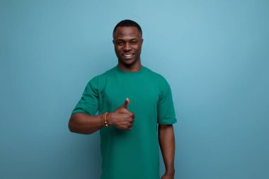 Kısa saçlı, kendine güvenen Afrikalı bir genç. Temel tişörtler giymiş. Fotokopi alanındaki gibi..