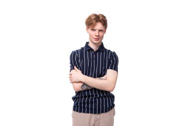 Yakışıklı 25 'li yaşlarda, beyaz arka planda dövmeleri olan, kolsuz tişört giyen sarışın bir adam..