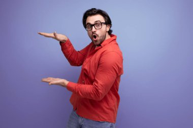 Gözlüklü genç ve enerjik esmer adam elleriyle el kol hareketi yapıyor..