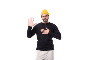 Siyah ceketli ve sarı şapkalı genç, vahşi bir erkek model kameraya çok samimi görünüyor..