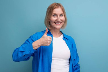 Çekici, güzel, sarışın, olgun, mavi arka planda, boşluklu bir kadın..