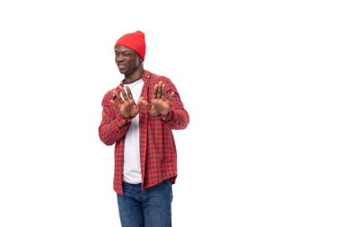 Şapkalı ve gömlekli genç Afrikalı bir adam, izole edilmiş beyaz arka plan yüzünden reddediyor..