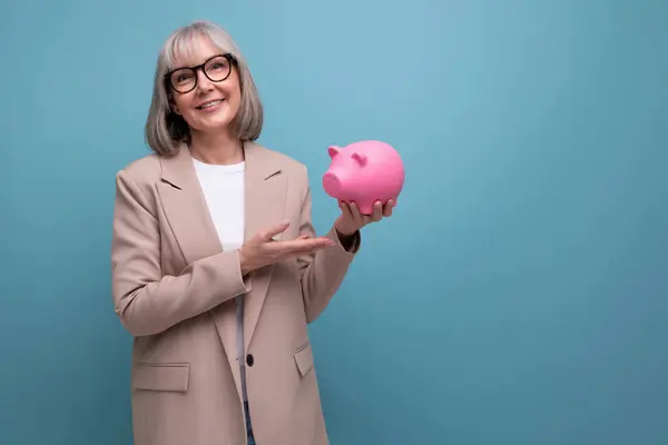 rich old woman with a piggy bank of money on a bright background with copy space.