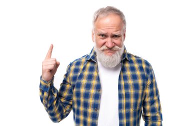 Bıyıklı, sakallı, olgun, beyaz saçlı emekli adam işaret parmağını beyaz arka planda kaldırdı..