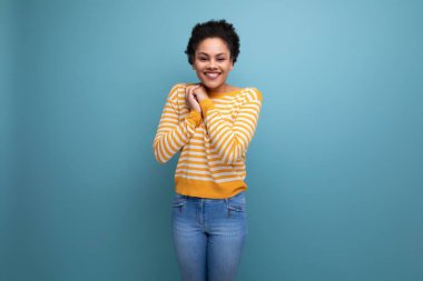 Stüdyo arka planında afro kıvırcık saçlı Latin bir model..