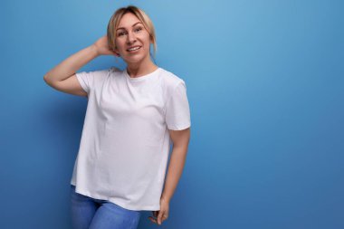 İş logosu için beyaz kollu tişörtlü sarışın bayan. Stüdyonun arka planında fotokopi alanı var..