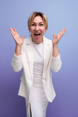 Genç neşeli pozitif sarışın zarif kadın yetişkin ceket ve elbise giyiyor..