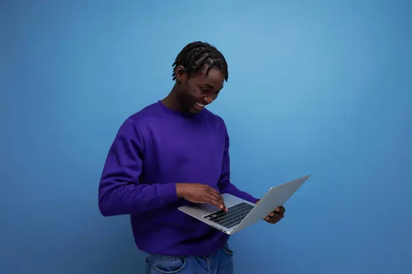 stock image freelancer african young brunette man with dreadlocks with laptop.