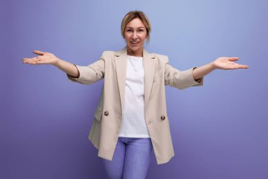 Ceketli sarışın genç bir kadın kollarını açmış karşılıyor..