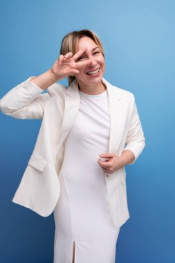 Genç, güler yüzlü, zarif kadın, pozitif yetişkin, ceket ve elbise giyiyor..