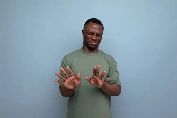 young handsome african man dressed in t-shirt shows denial and disagreement with hands.