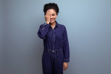 Mavi kot pantolon giymiş, kıvırcık saçlı genç İspanyol iş kadını. Kopya alanı arka planında izole edilmiş..