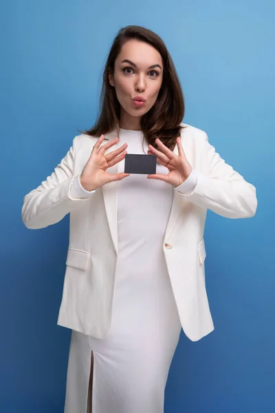 stock image successful business. brunette woman in dress holding bank card for shopping.