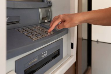 ATM 'deki kadın düğmesine basıyor.