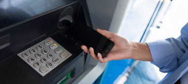Bir kadının eli ATM 'ye akıllı telefon uyguluyor..