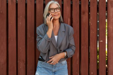 Başarılı, orta yaşlı, şık giyinmiş bir kadın boş zamanlarını dışarıda gezerek geçiriyor..