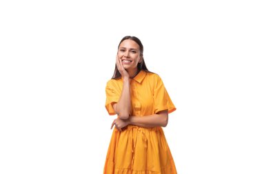 Turuncu elbiseli, siyah saçlı ince kadın flört ediyor ve gülümsüyor..