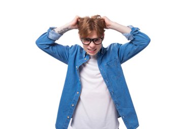 Bakır saçlı genç Avrupalı adam kot gömlek giyiyor. Beyin fırtınası yapıyor..