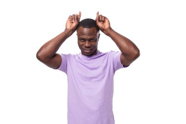 Açık leylak rengi tişört giymiş genç, şanslı Amerikalı adam parmaklarını çapraz yaptı..