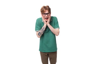 Kırmızı saçlı, yeşil tişörtlü ve beyaz arka planda fotokopi alanı olan genç bir adamın portresi..