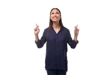 Genç, gülümseyen, ince bir kadın, siyah saçlı, mavi bluz giymiş..