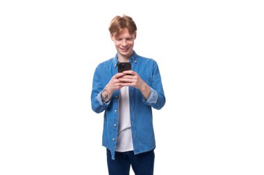 Kısa kızıl saçlı beyaz bir adam verileri akıllı bir telefona yüklüyor. e-iş konsepti.