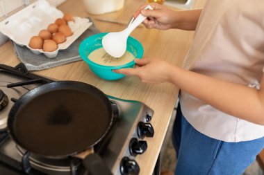 Kadın hamuru tavaya serer..