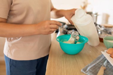 Bir hostes mutfakta bir kase krep hamuru tutuyor..