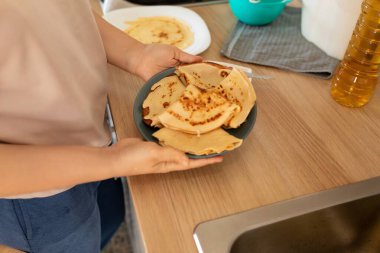 Bir kadın Malenitsa için hazır krep tabağı tutar..