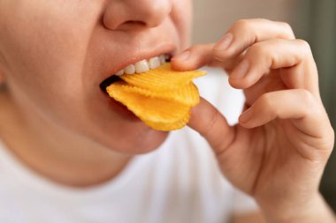 Sağlıksız yiyecekler yiyen genç bir kadın..