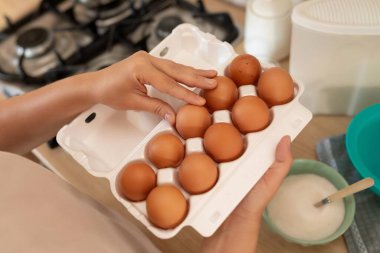 Eller masanın üstündeki tepsiden bir yumurta çıkarır..