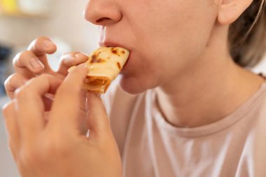 Kadın, mutfakta kreplerle kahvaltı yapıyor..