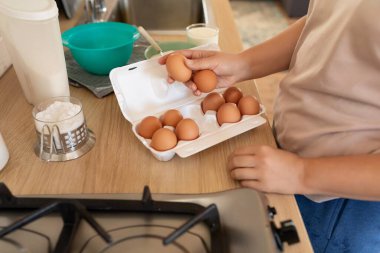 Kadın masadaki yemek için yumurtaları hazırlar..
