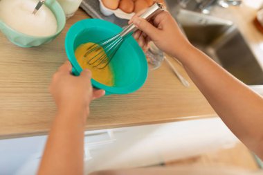 Kahvaltı hazırlamak için derin bir kasede yumurta çırpıyorum..