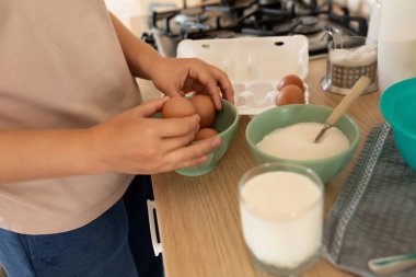 Mutfaktaki bir kadının ellerinde tavuk yumurtalarını yakın plan çekiyoruz..