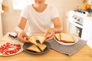 Kadın pişmiş ekmeği dilimleyip üçgen yapmış..