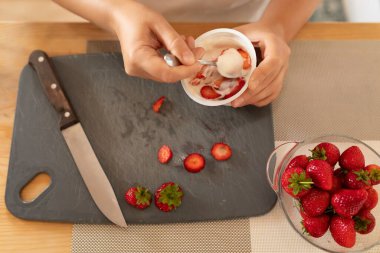 Ekşi krema ve çilekli tatlıya yakın plan..