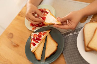 Bir kadın mutfakta atıştırmak için sandviç yapar..