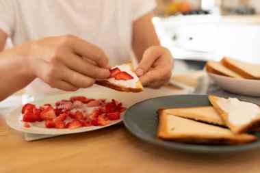 Kadın eli ev yapımı çilekli sandviç yapar..