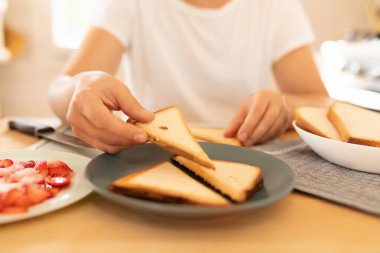 Mutfağında ekmek kızartan bir kadın..