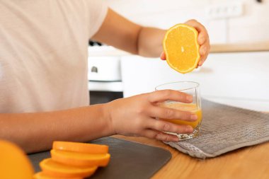 Kadınların elleri meyve suyu için portakal sıkar..