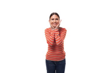 Genç gülümseyen Avrupalı sıska kadın günlük turuncu süveter ve beyaz arka planda fotokopi alanı olan kot pantolon giyiyor..