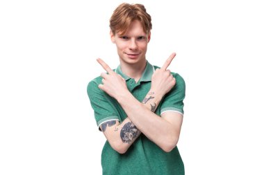 Genç, kızıl saçlı, yeşil tişörtlü bir adam. Arka planda fotokopi alanı olan bir reklam için elini yere koydu..