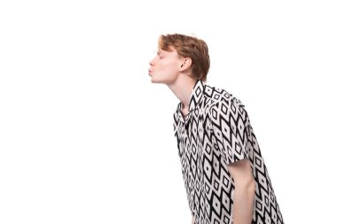 Yazlık gömlekli, kızılımsı altın saçlı, beyaz, aşık genç bir adam hava öpücüğü yolluyor..