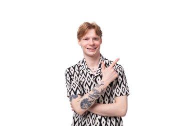 Kısa kollu tişört giymiş, kollarında dövmesi olan, kızıl saçlı genç bir adam reklam için elini uzatıyor. iş kavramı.