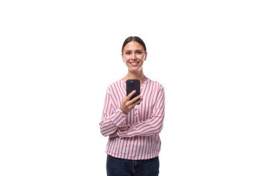 Genç, başarılı, esmer, at kuyruklu, çizgili pembe ve beyaz gömlekli kadın telefonda konuşuyor..