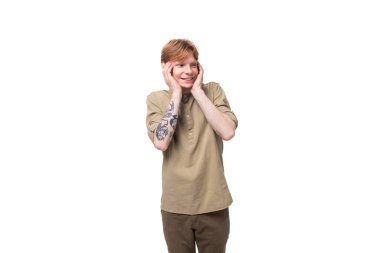 Stüdyoda beyaz arka planda bej gömlekli, kızıl saçlı genç bir adamın yakın çekimi..