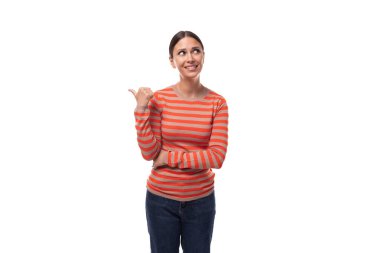 Siyah saçlı, çizgili turuncu ceketli beyaz bir kadın elleriyle hareket ediyor ve dikkat çekiyor..