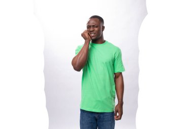 Açık yeşil tişörtlü, beyaz arka planda kotlu ve fotokopi alanı olan yakışıklı bir Afrikalı..
